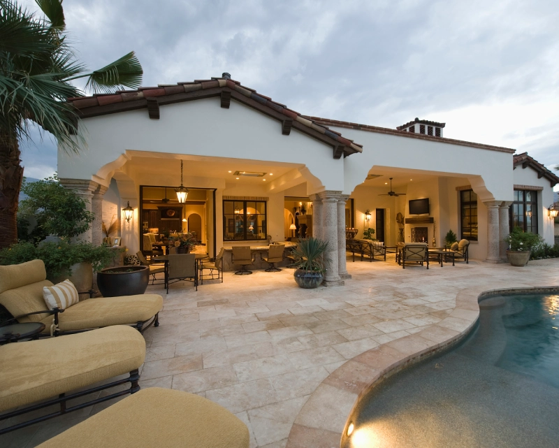 Luxurious outdoor patio and pool area at a stylish home during dusk.