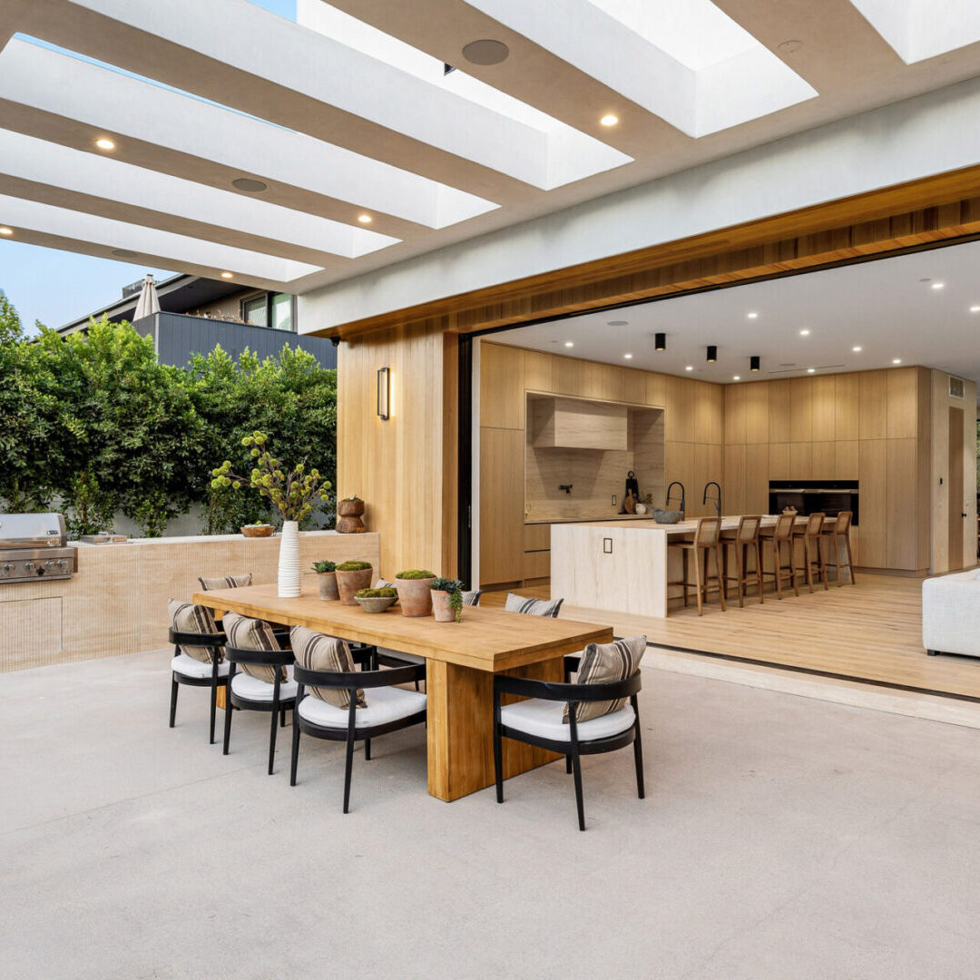 Elegant indoor-outdoor dining area with wooden furniture and modern design.